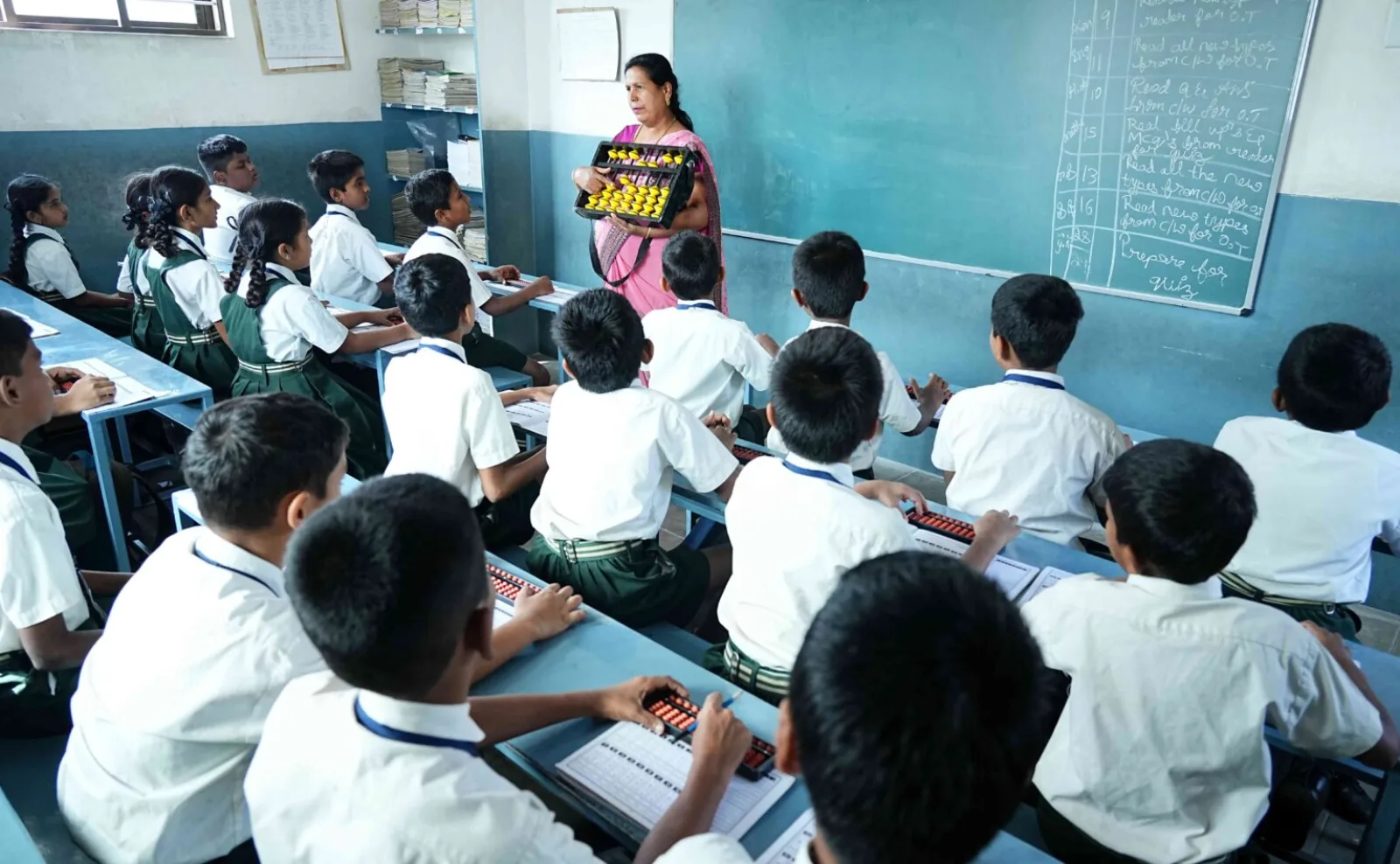 Primary school children seated at their desks writing in a classroom