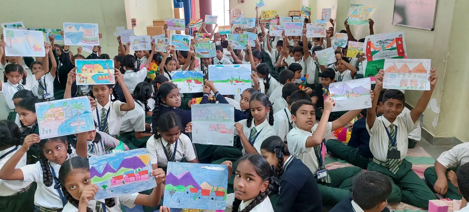 A large group of students holding up their drawings during an art competition