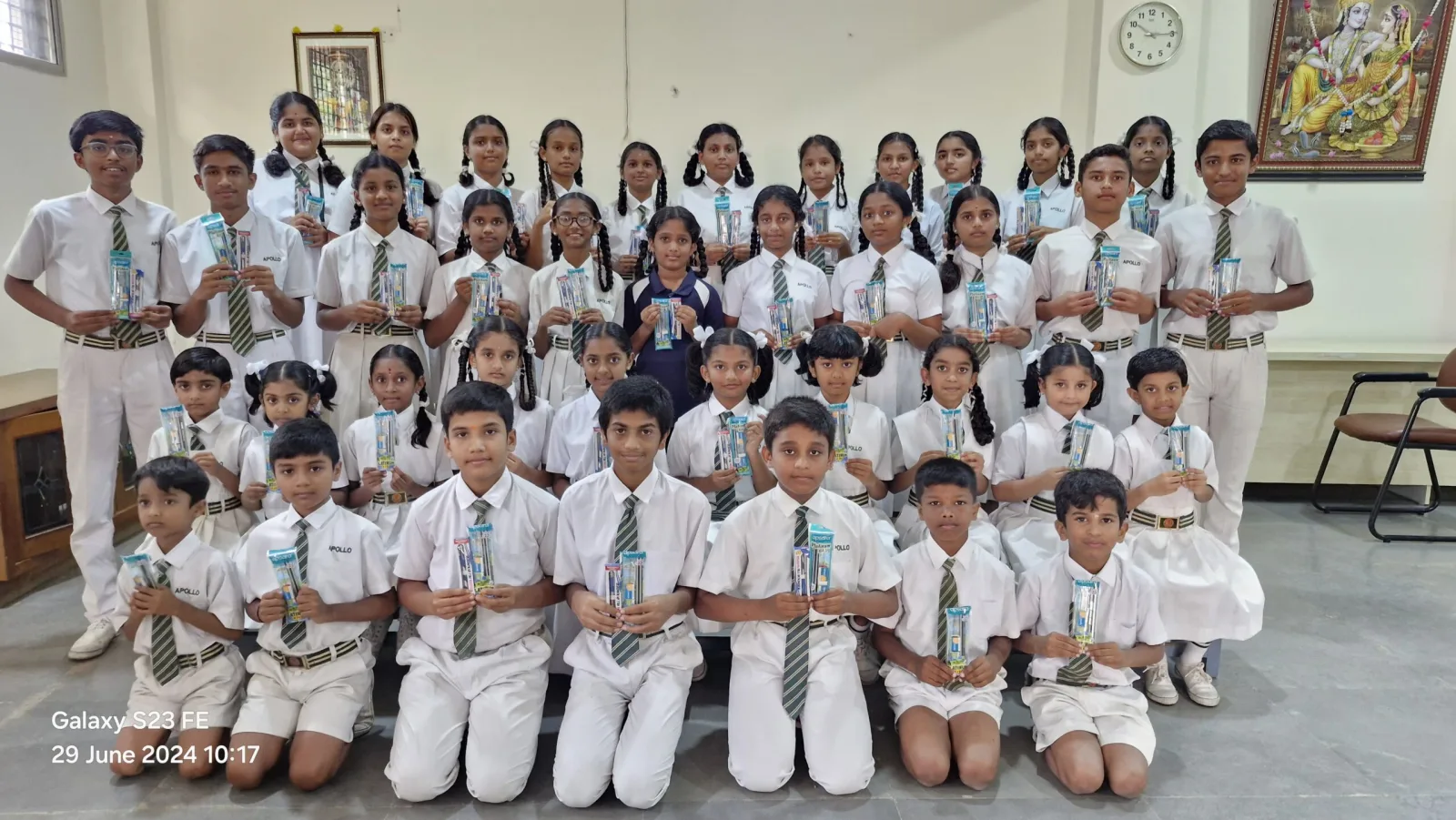 A large group of students holding eco-friendly kits given as prizes at a school event