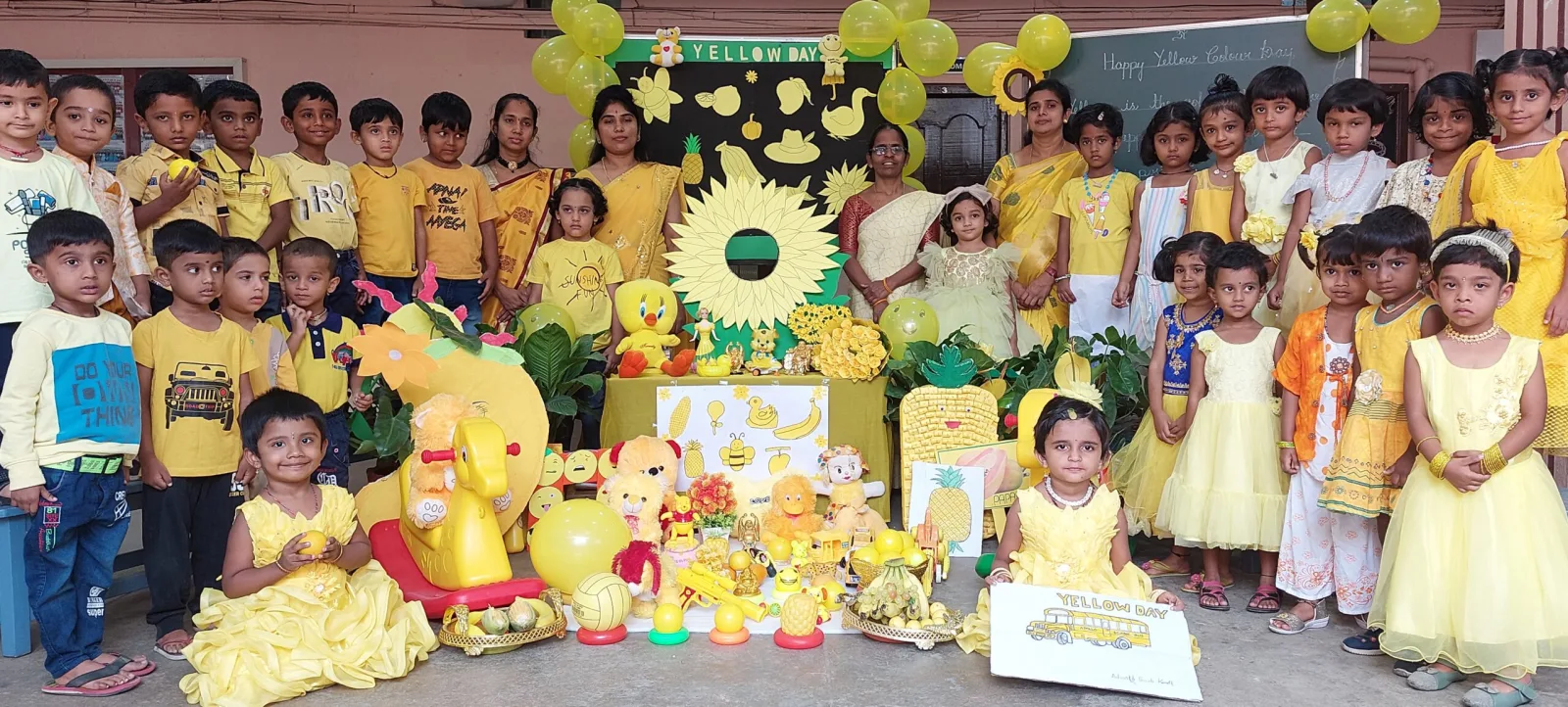 Students dressed in yellow for a themed celebration day, surrounded by yellow decorations