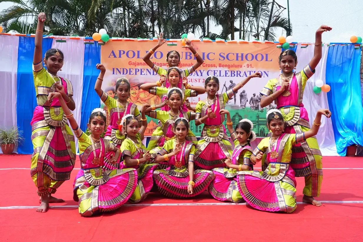 Students in colourful traditional costume performing a group dance outdoors