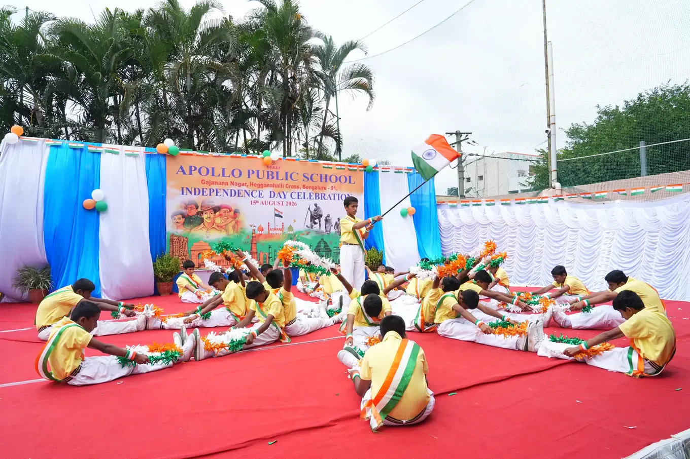 Students in tricolour costume forming a patriotic dance formation on the school ground