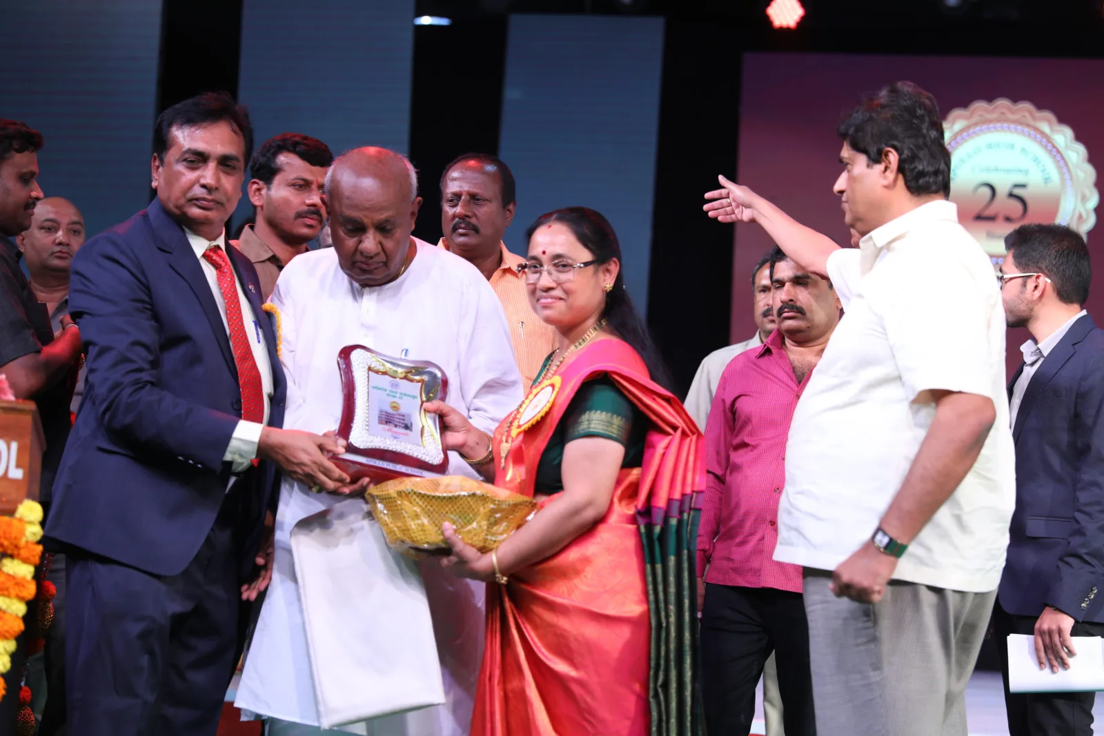 A guest of honour presenting a memento to a member of school management on stage
