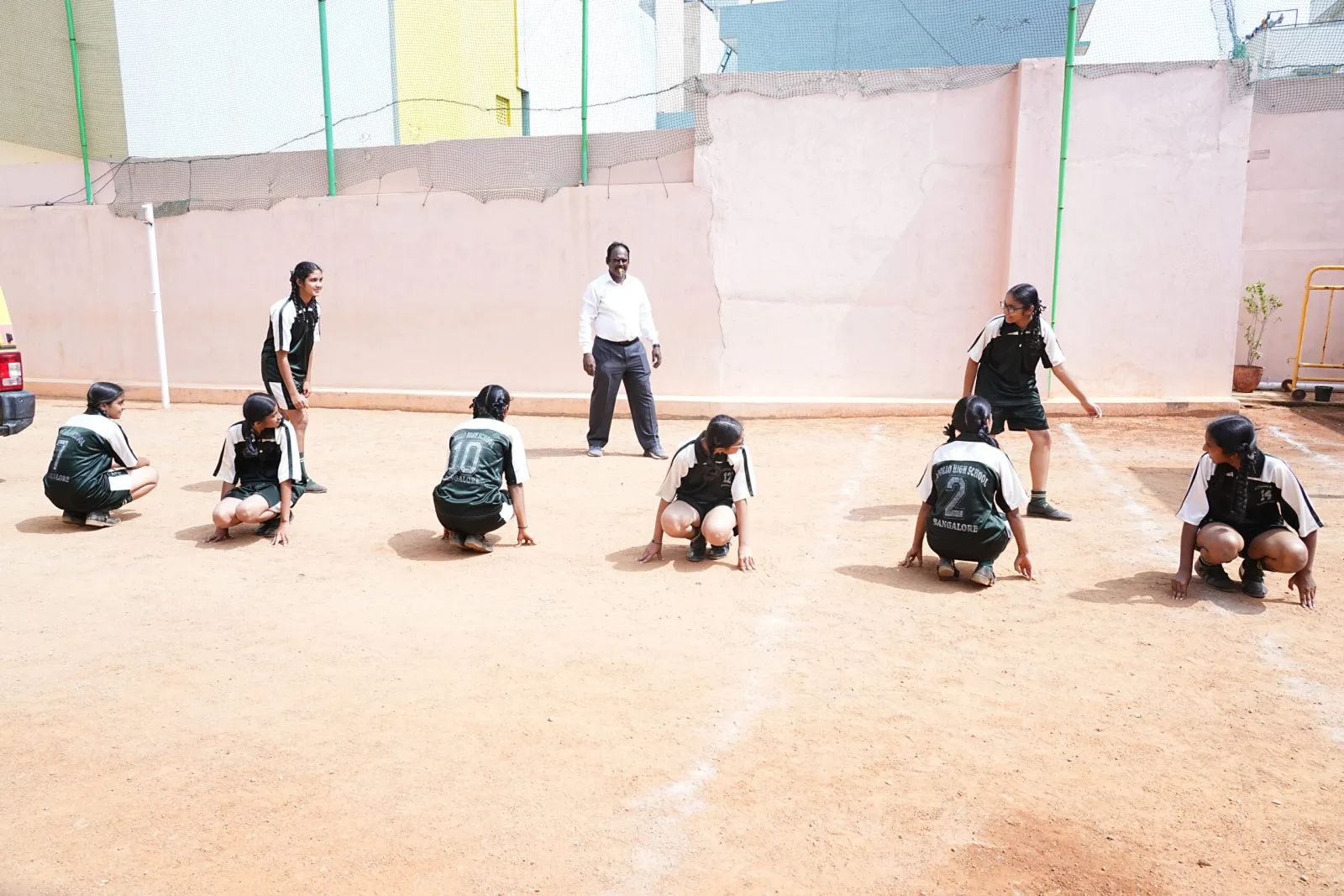 Students in an exercise formation on the school ground with a teacher