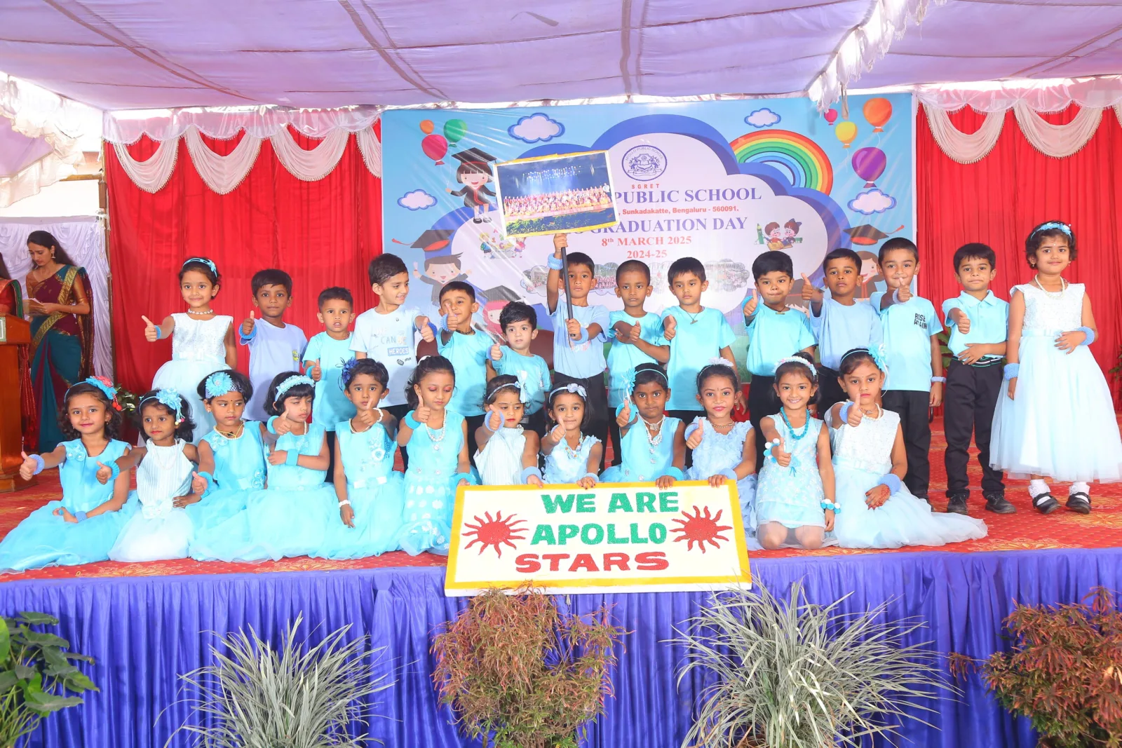 UKG children posing together on stage next to a "We Are Apollo Stars" sign